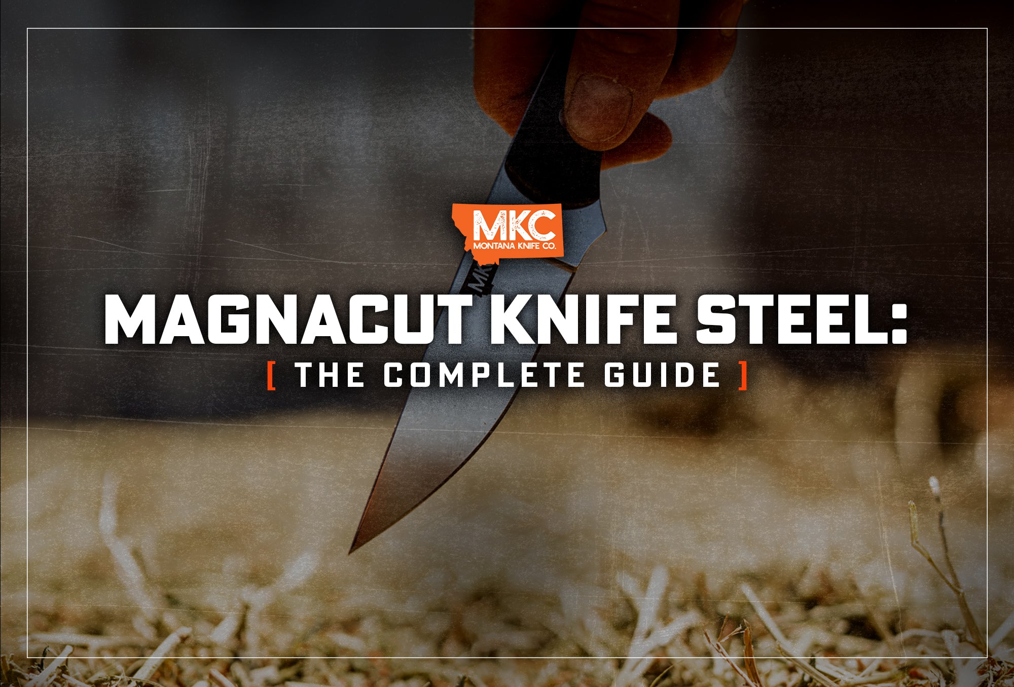 A hand holds a CPM MagnaCut knife with the blade pointed toward the straw-covered ground.