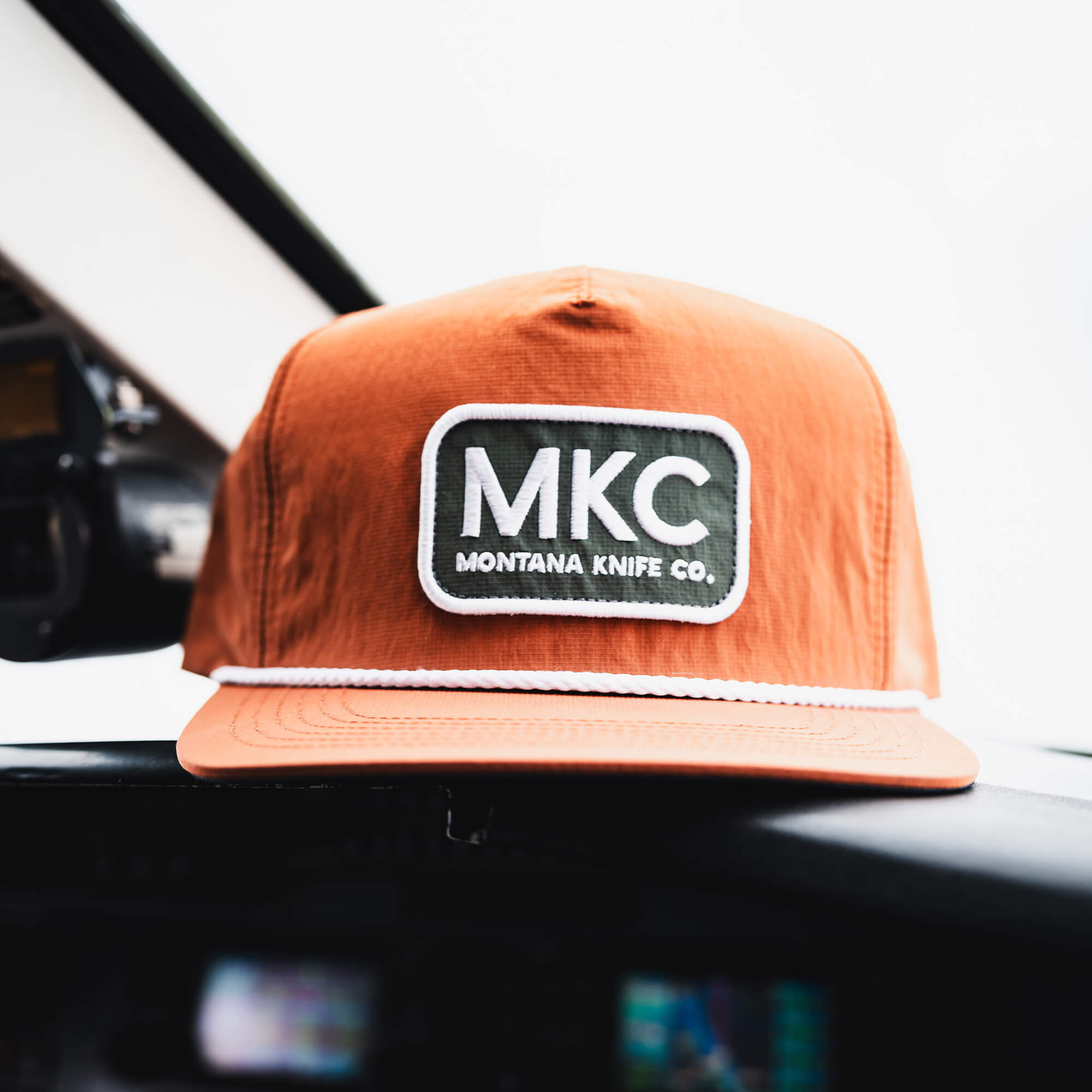 Rust-colored MKC River Rope Hat featuring a prominent MKC logo, designed for outdoor enthusiasts and working professionals.