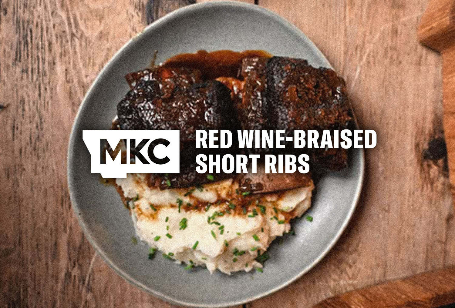 Red wine-braised short ribs with mashed potatoes on a dinner plate.