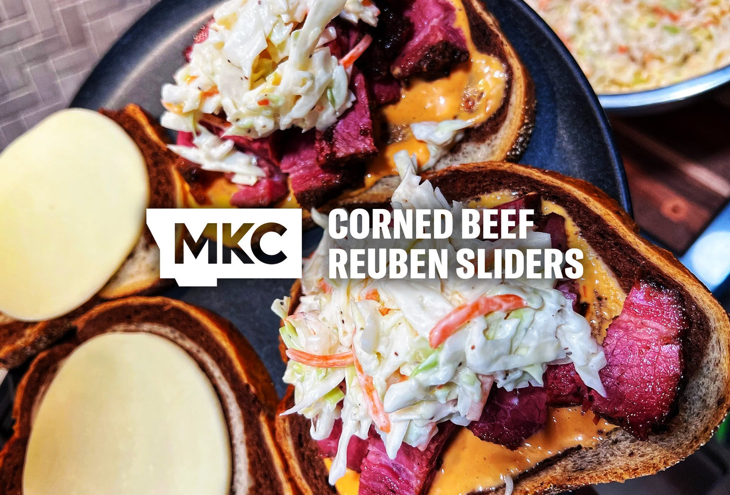 Corned beef Reuben sliders on toasted bread, topped with creamy coleslaw and sauce.
