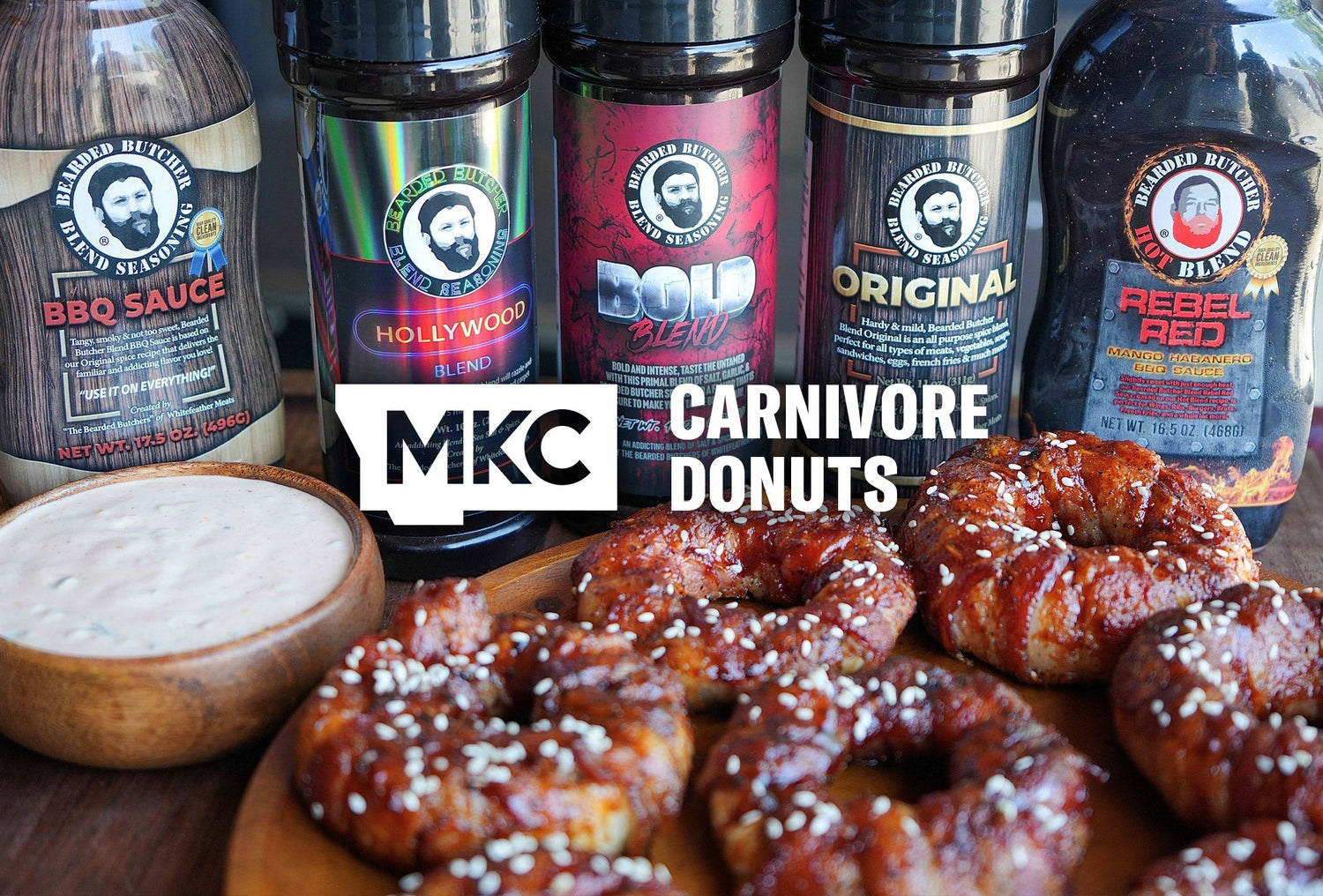Carnivore donuts wrapped in bacon with sesame seeds, served with dipping sauce and Bearded Butcher seasonings.