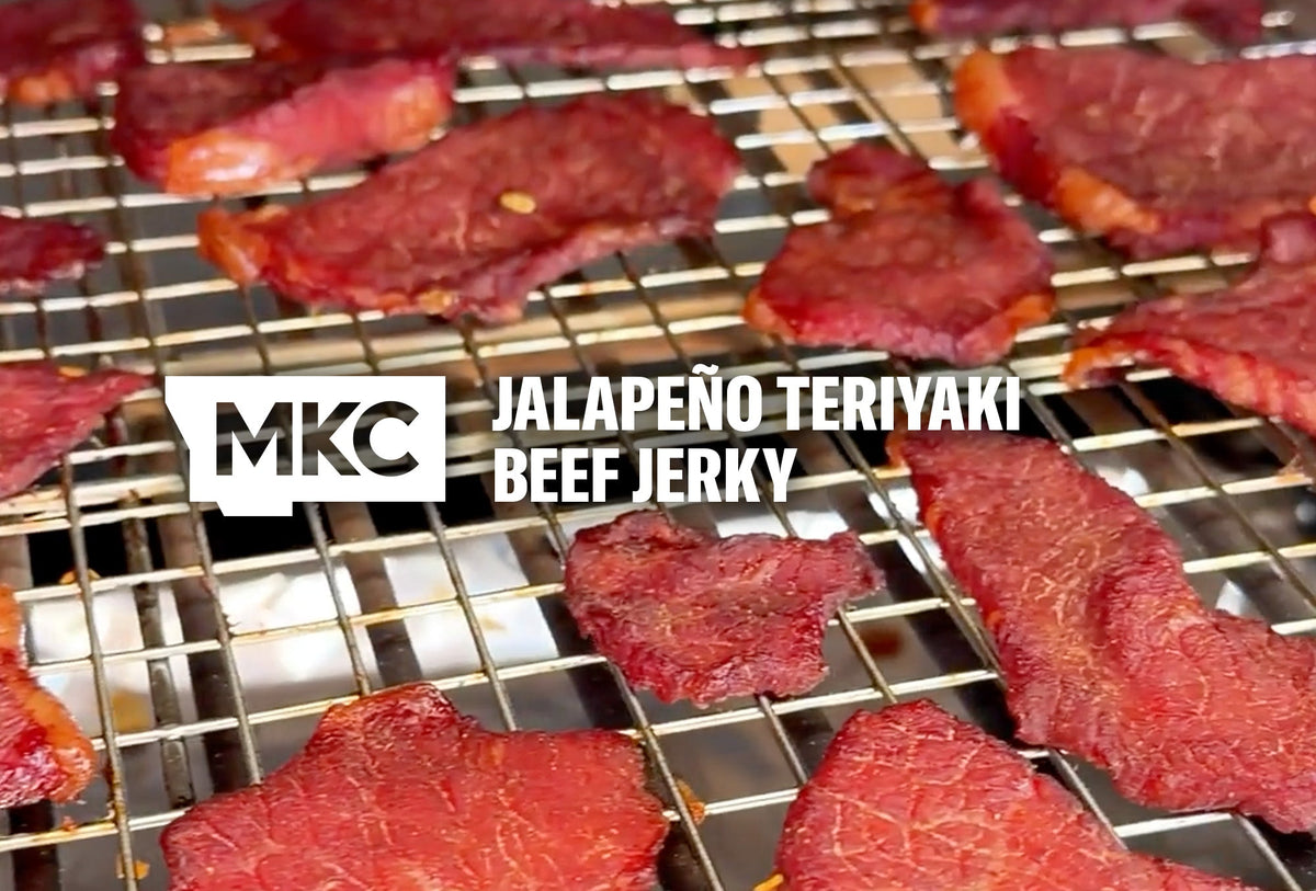 Smoked teriyaki beef jerky pieces resting on a wire rack with a rich, dark finish.