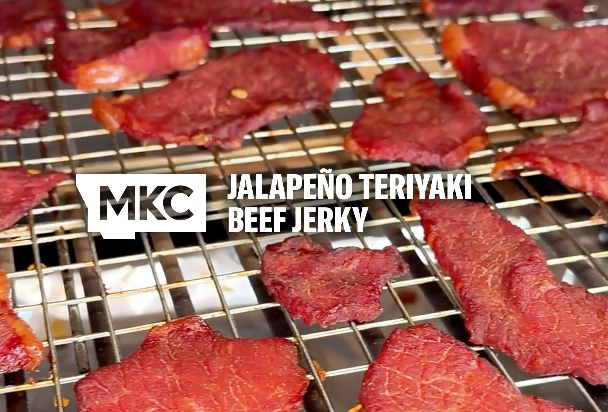 Smoked teriyaki beef jerky pieces resting on a wire rack with a rich, dark finish.