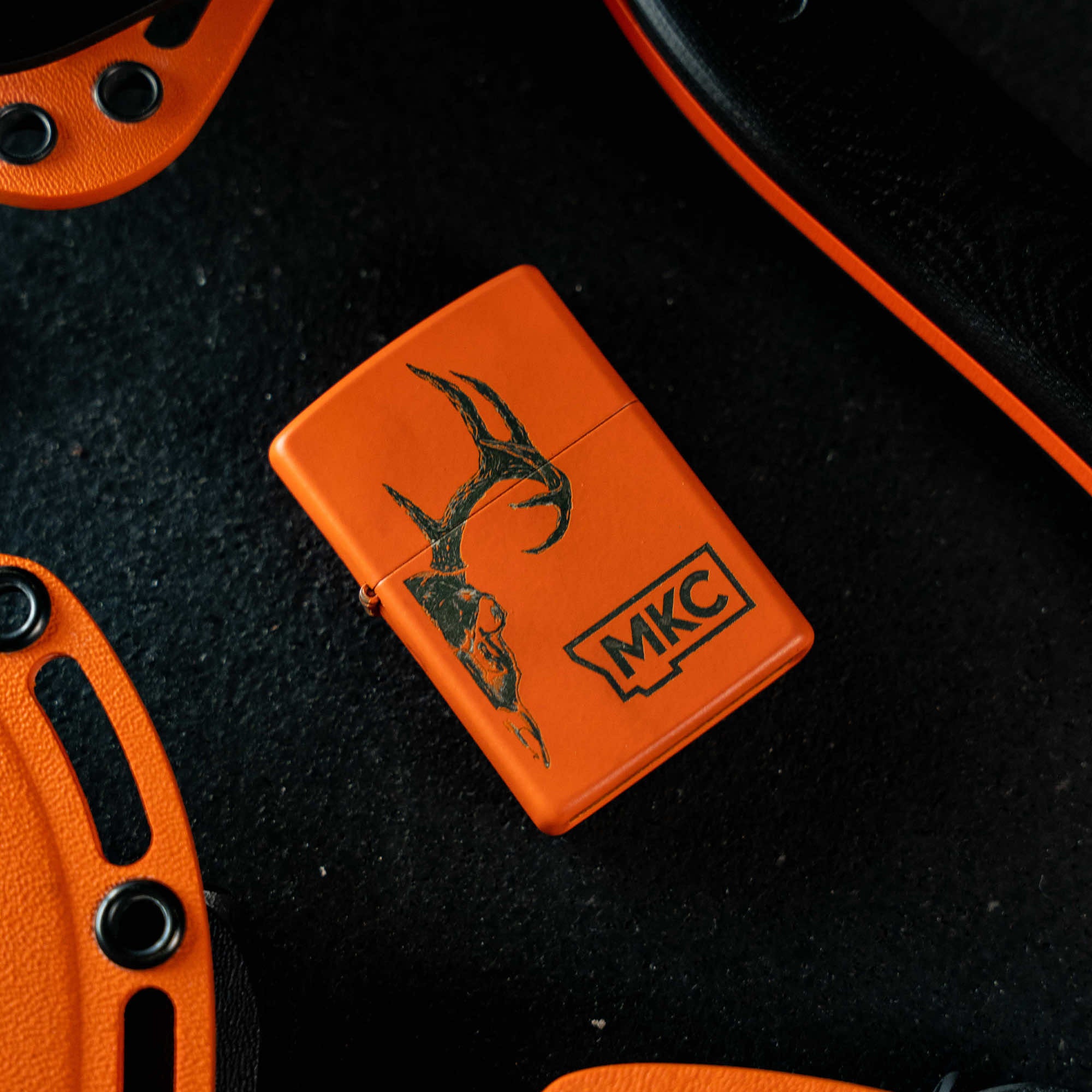 Limited edition blaze orange Cerakote Zippo lighter featuring MKC logo, designed for outdoor enthusiasts and hunters.
