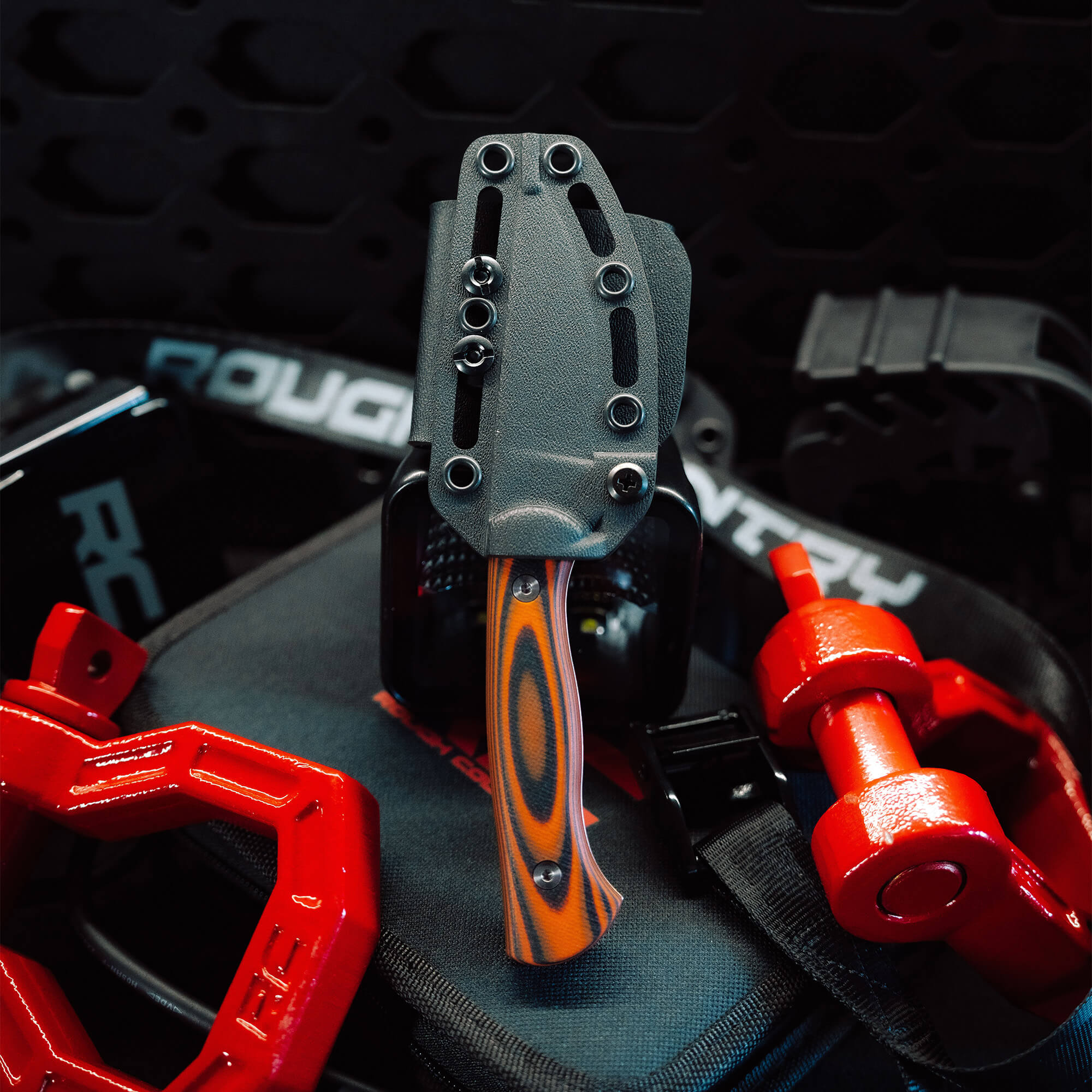Rough Country Magnacut Blackfoot 2.0 knife displayed on gear, featuring a sleek design and vibrant handle.